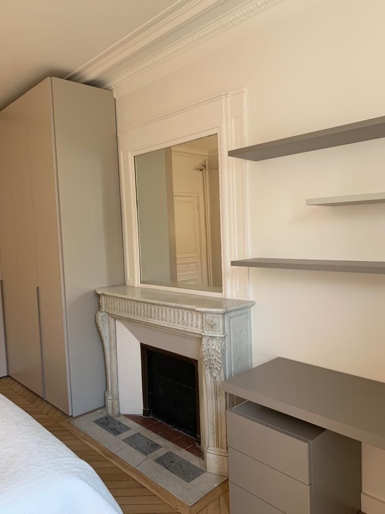 Chambre avec cheminée conservée et rangements sur mesure de part et d’autre