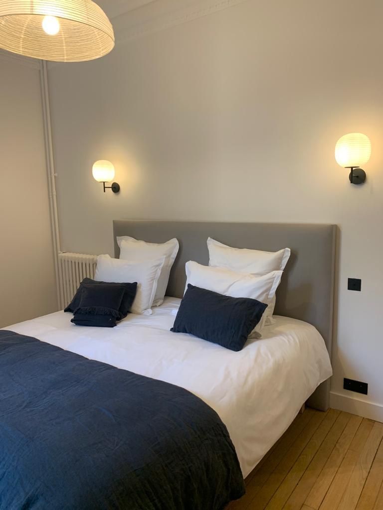 Chambre avec tête de lit habillée et appliques murales posées
