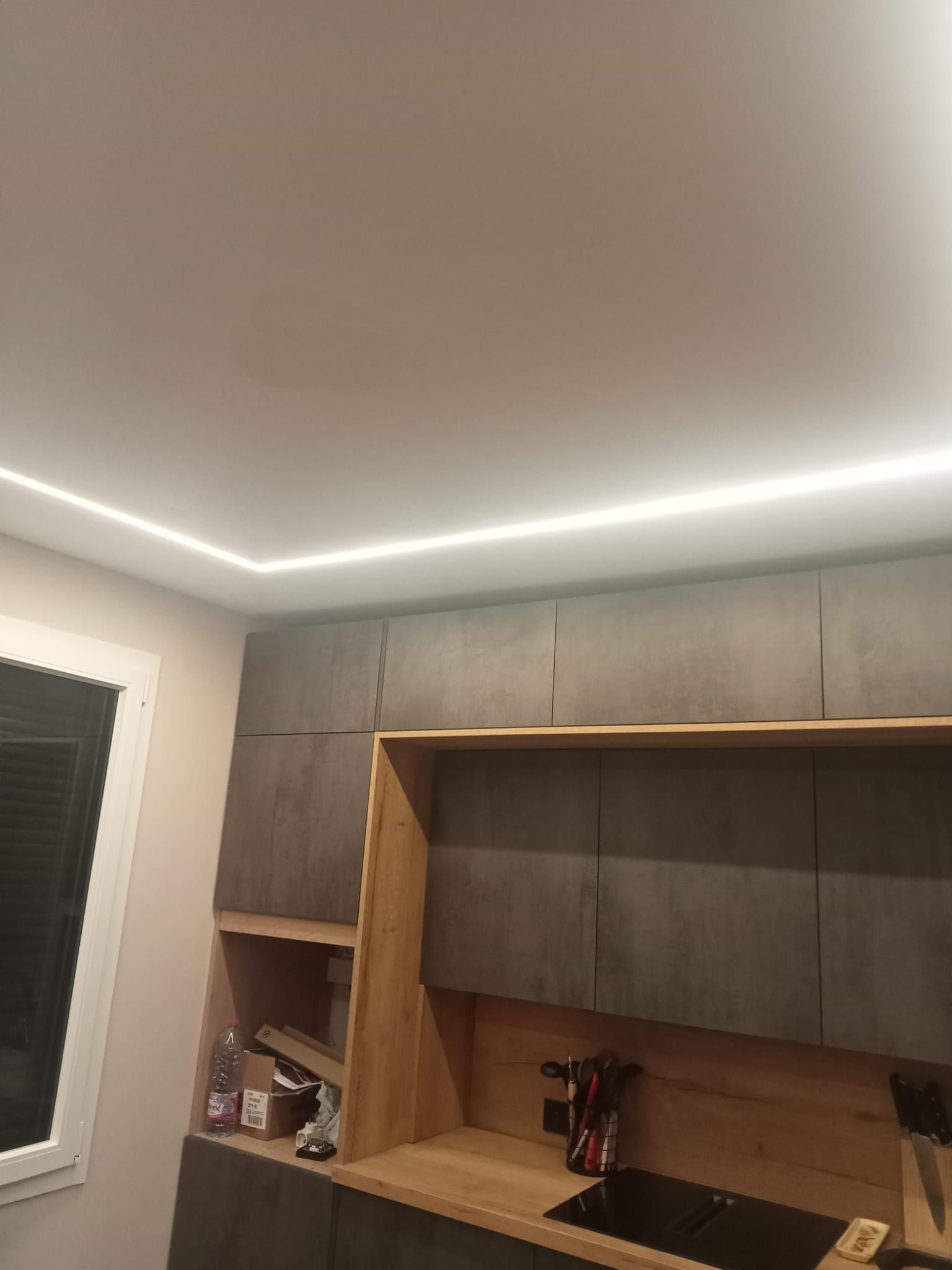 Niche en bois intégrée aux meubles hauts, au-dessus de la plaque à induction et du plan de travail