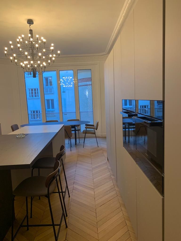 Cuisine avec îlot bar, suspension au-dessus du plan et parquet chevron
