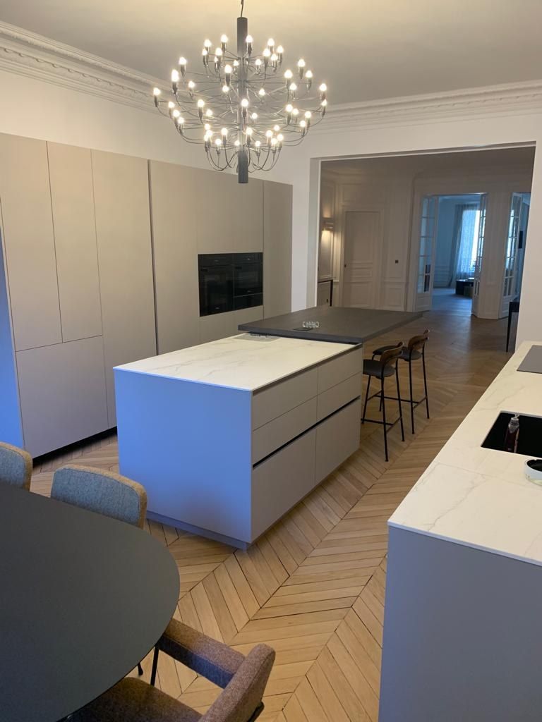 Cuisine blanche avec grand îlot central et lustre contemporain