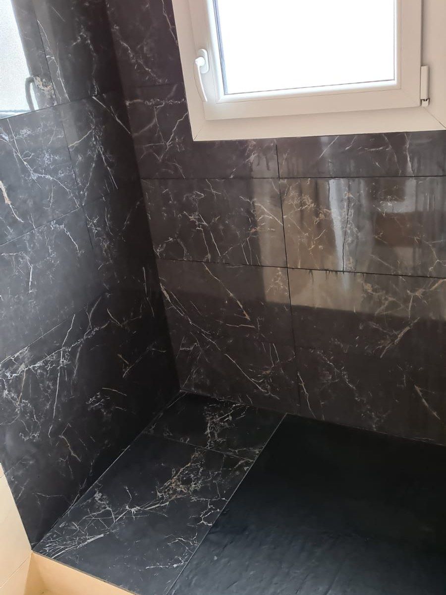 Douche à l'italienne habillée de grand format effet marbre brun, receveur à carreler