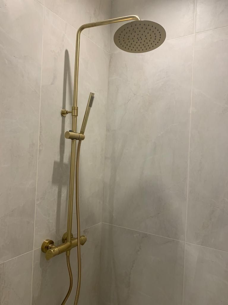 Douche à l'italienne carrelée grand format, colonne et robinetterie laiton brossé