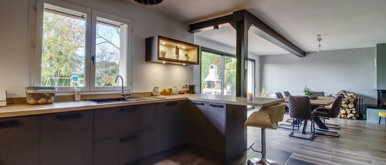 Cuisine ouverte bois et anthracite sous charpente apparente