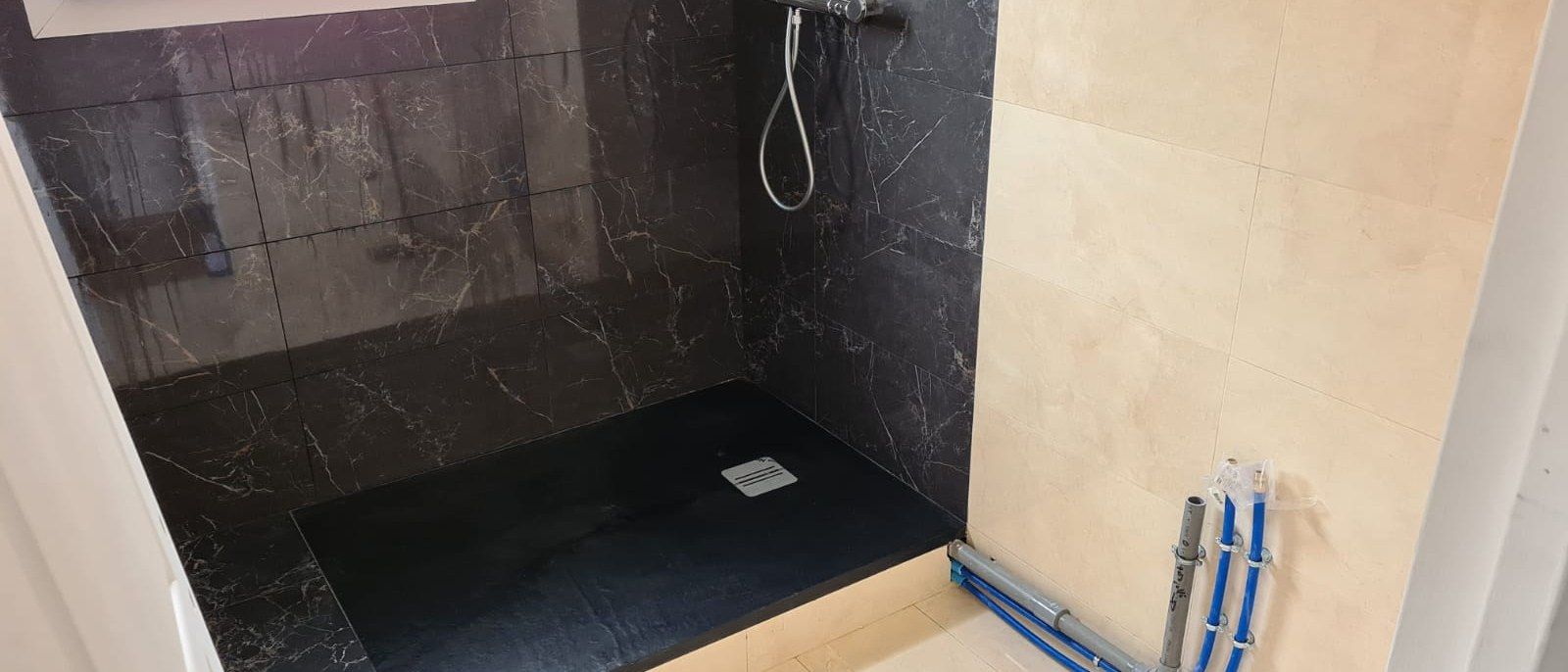 Douche à l'italienne en cours de pose, alimentations et évacuation apparentes
