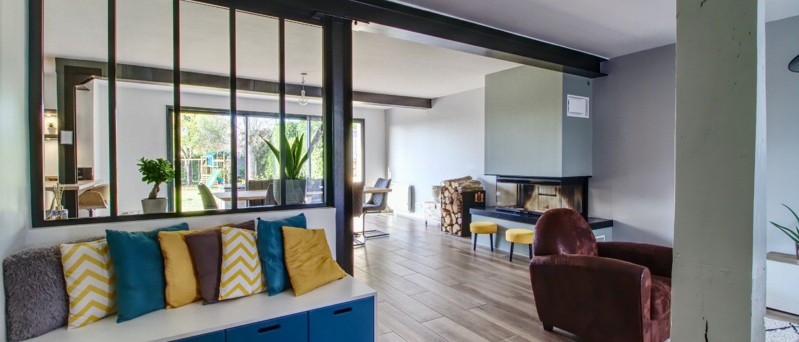 Séjour ouvert séparé par une verrière atelier, banquette sur mesure