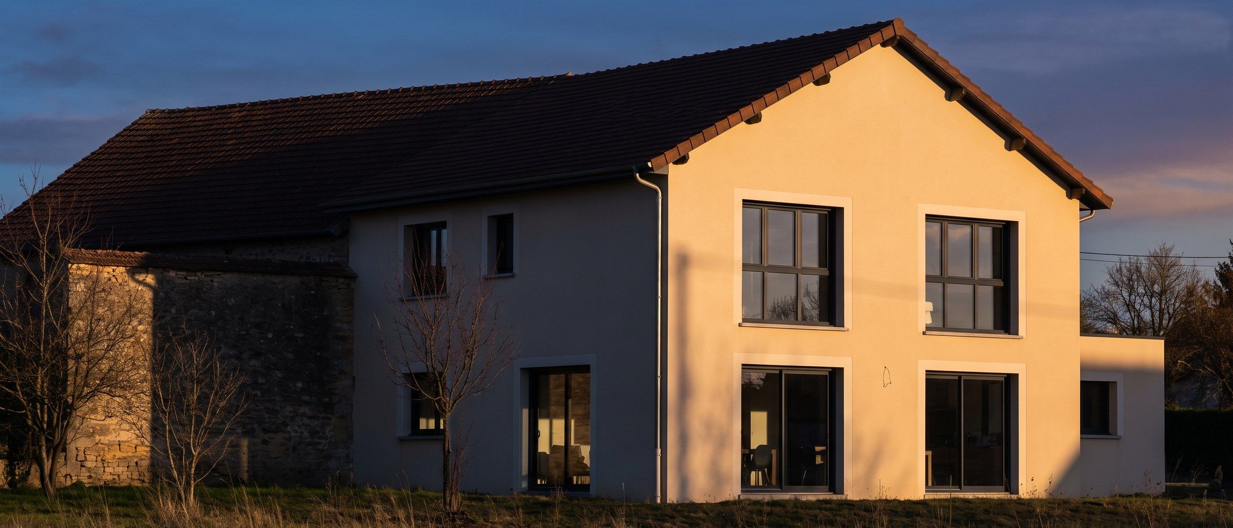 Pavillon francilien après rénovation, façade enduite éclairée au soleil couchant