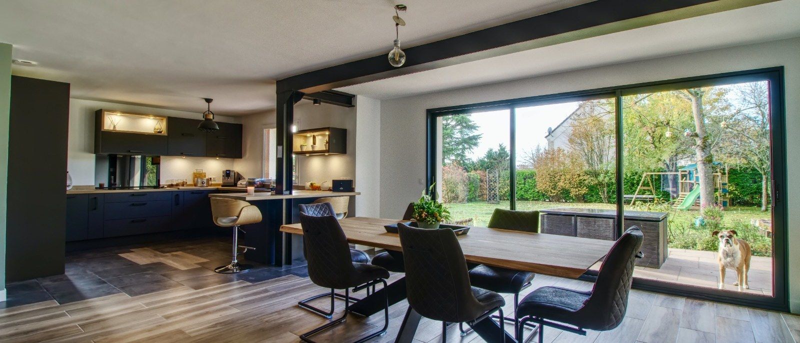 Salle à manger ouverte sur le jardin par de grandes baies vitrées