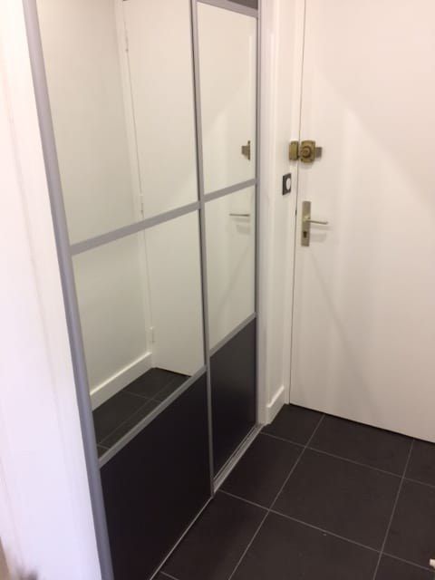Porte coulissante vitrée à cadre métallique dans un couloir