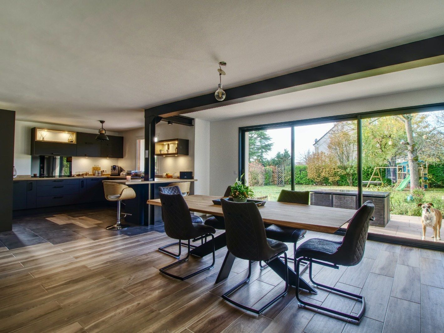 Salle à manger ouverte sur le jardin, sol grand format et menuiseries anthracite