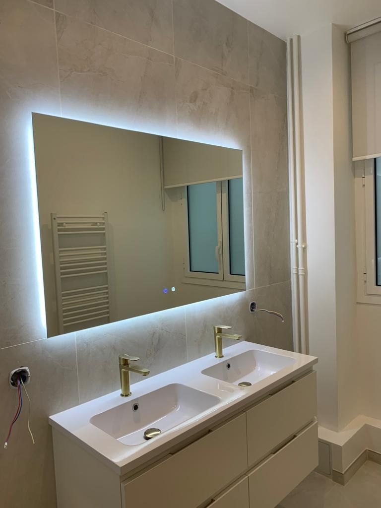 Salle de bain avec miroir rétroéclairé, double vasque et sèche-serviettes intégré