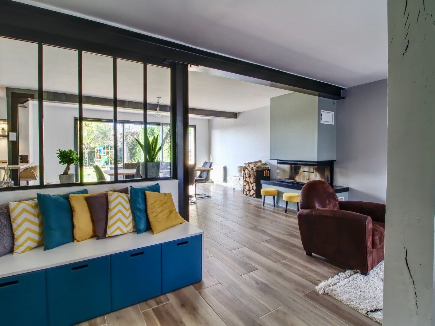Séjour séparé par une verrière atelier, banquette sur mesure et parquet grande largeur